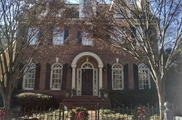 a brick house with white trim and arched windows