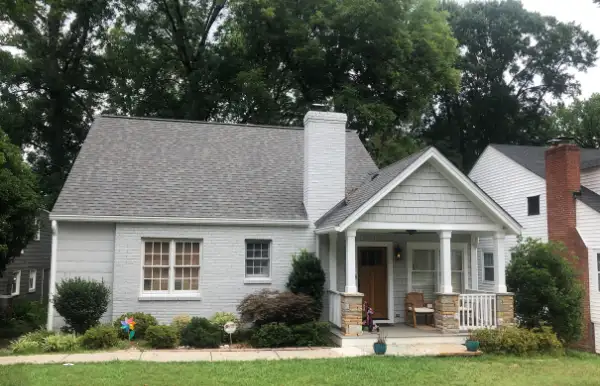 a gray house with white trim and a porch